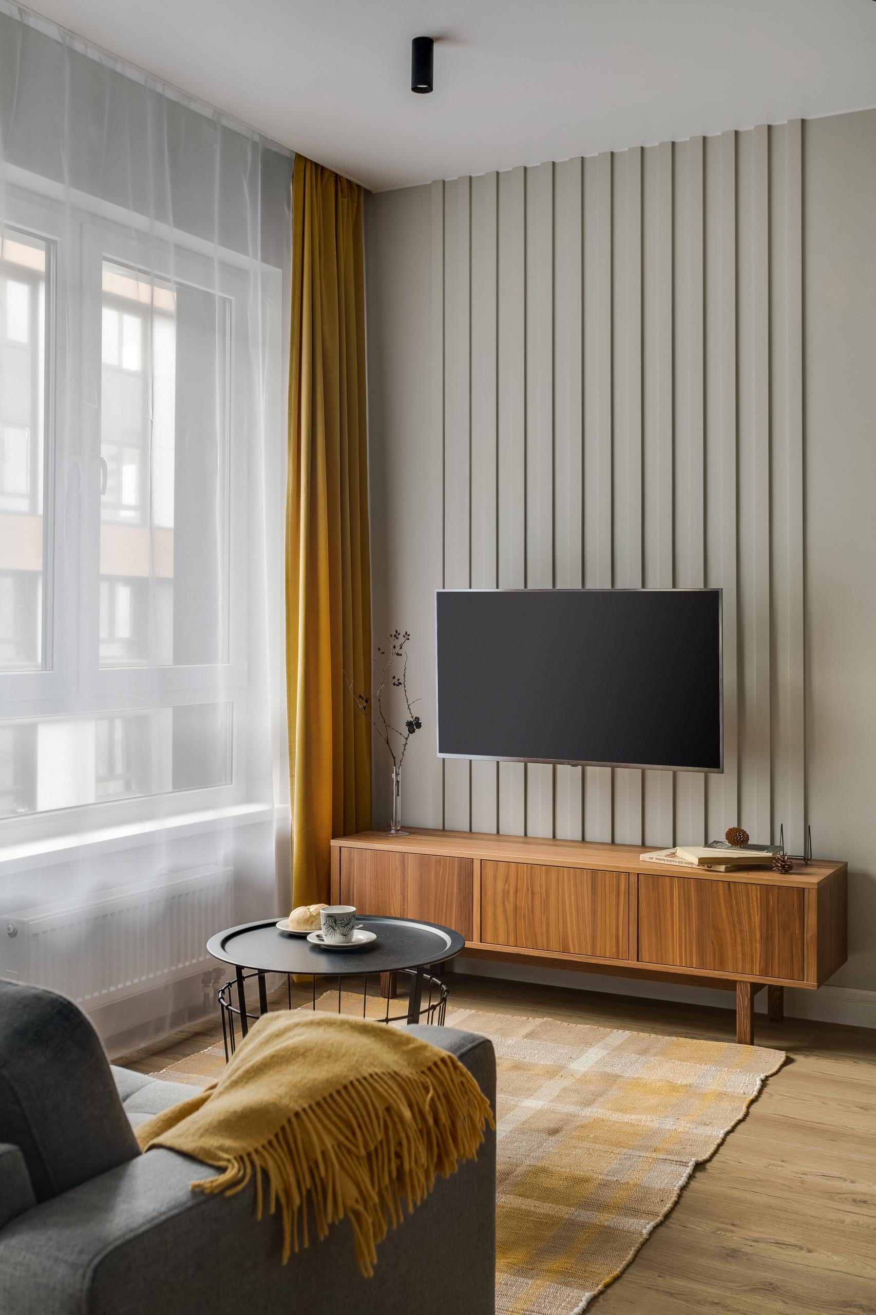 Интерьер гостиной cтеной с телевизором, телевизором на рейках, телевизором на стене, нишей для телевизора и керамогранитом на стену с телевизором в современном стиле