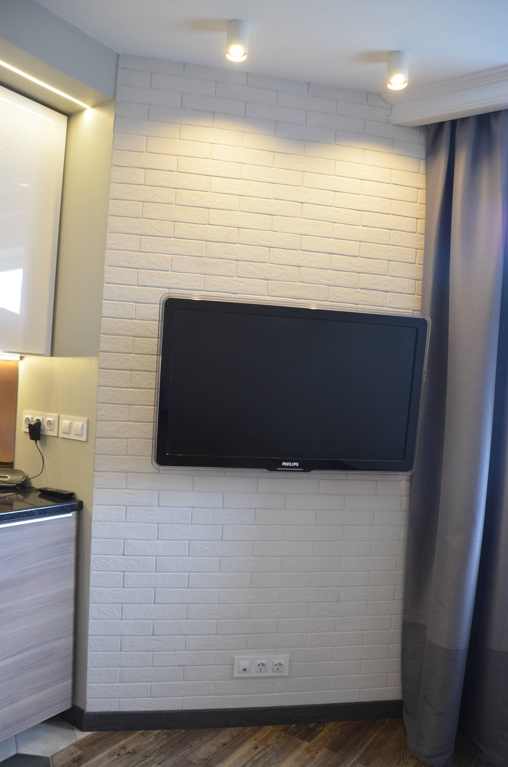 Интерьер cтеной с телевизором, телевизором на рейках, телевизором на стене, керамогранитом на стену с телевизором и подсветкой настенной в стиле лофт
