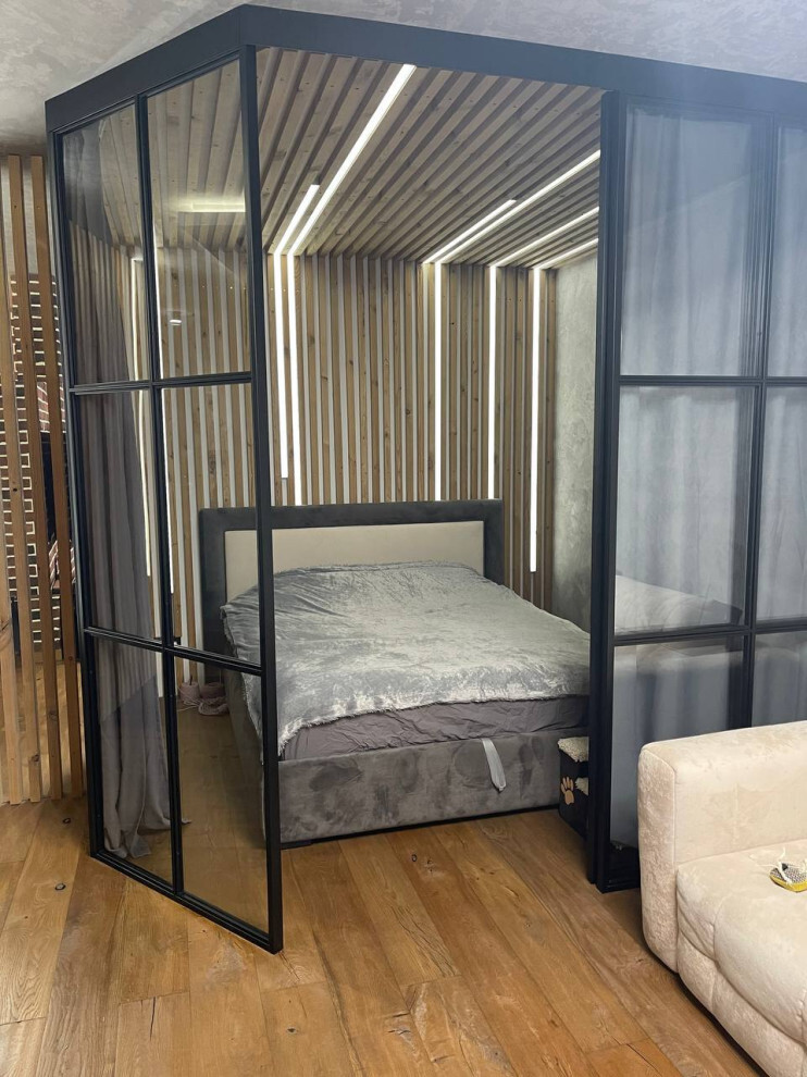 Интерьер спальни с кроватью в нише, перегородкой и перегородкой раздвижной в стиле лофт
