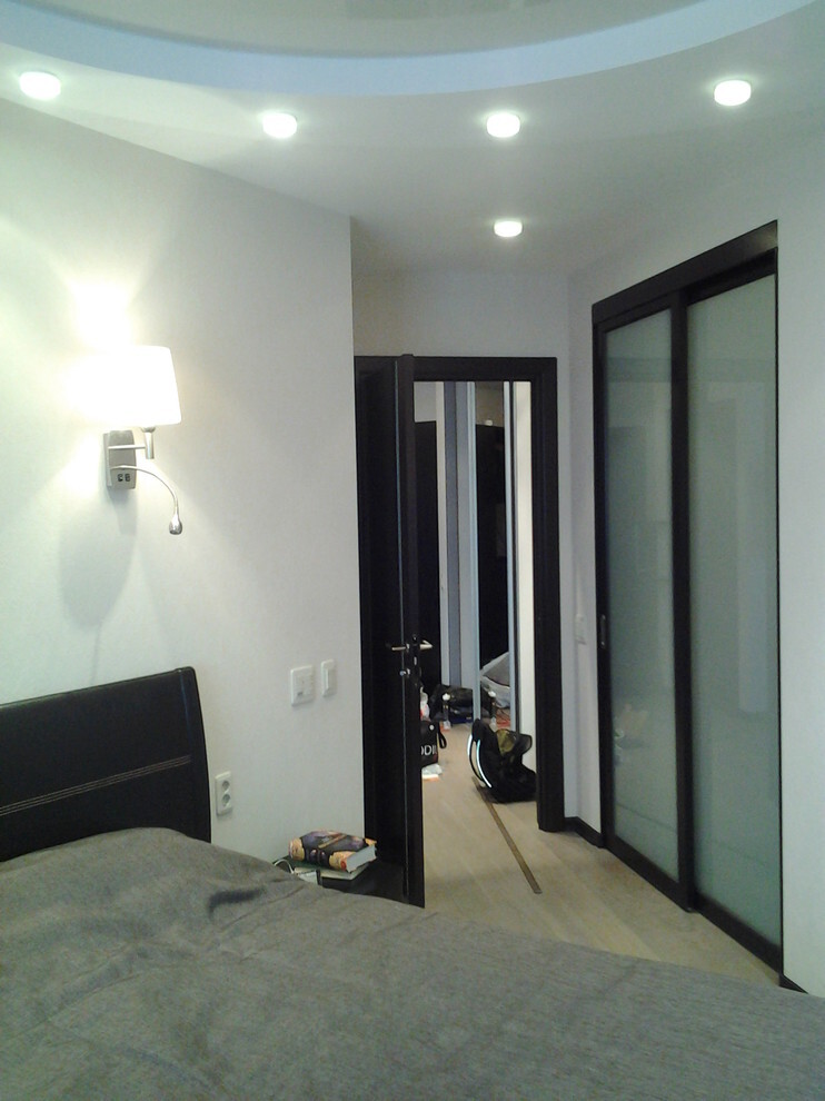 Интерьер спальни с зеркалом на двери в современном стиле