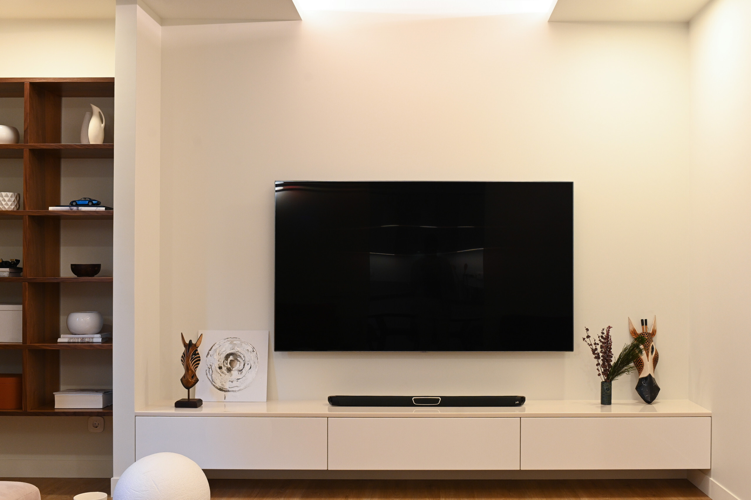 Интерьер гостиной с панно за телевизором, стеной с телевизором, телевизором на рейках, телевизором на стене, нишей для телевизора и керамогранитом на стену с телевизором