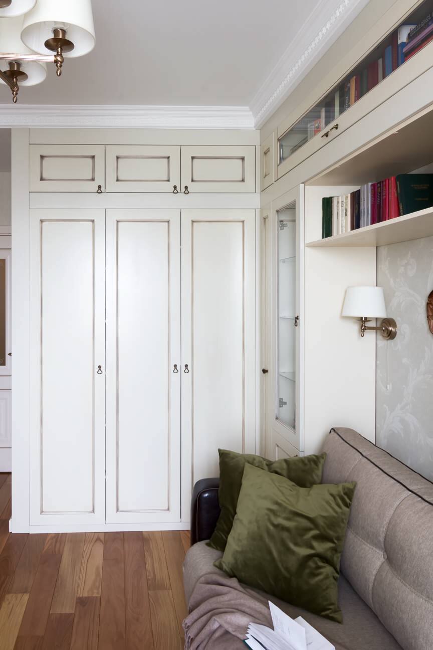 Интерьер спальни с шкафами вокруг двери в классическом стиле