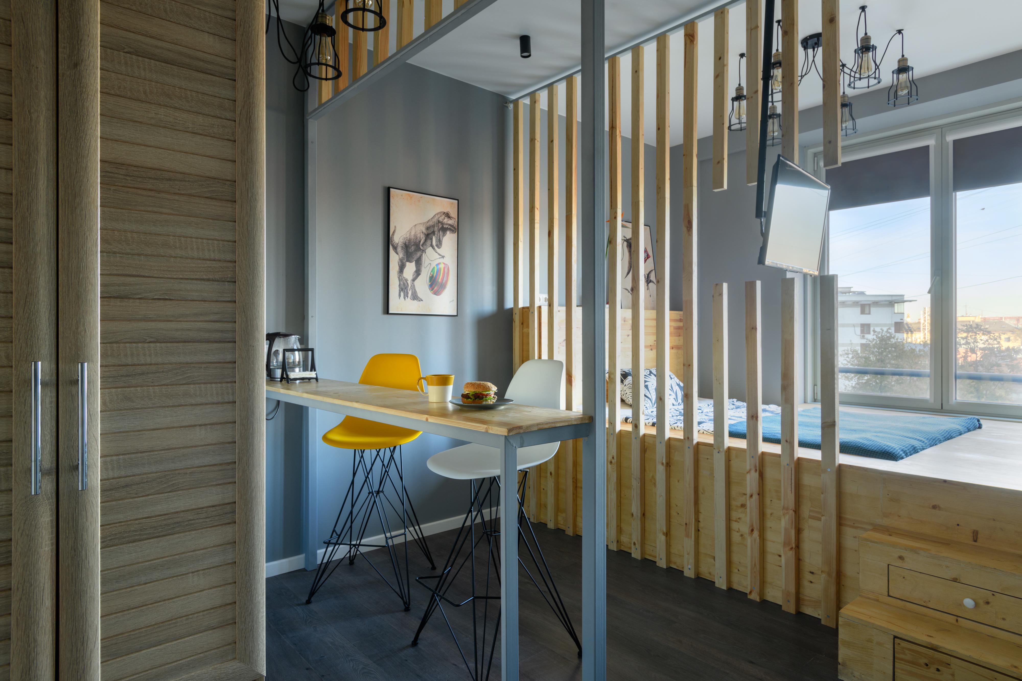 Интерьер гостиной с в деревянном доме, зонированием рейками и вертикальными жалюзи в стиле лофт