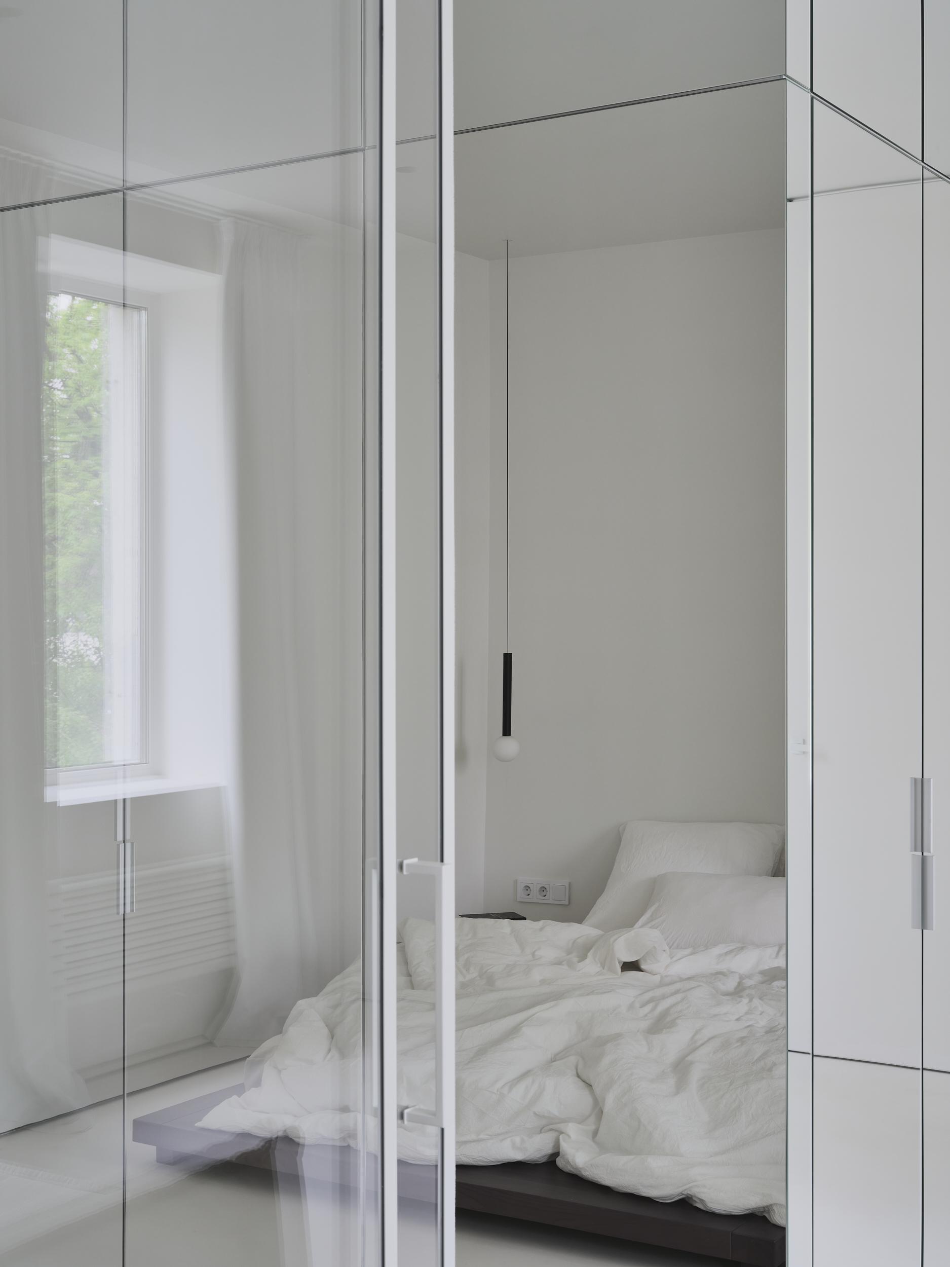 Интерьер спальни с зеркалом на двери в стиле лофт