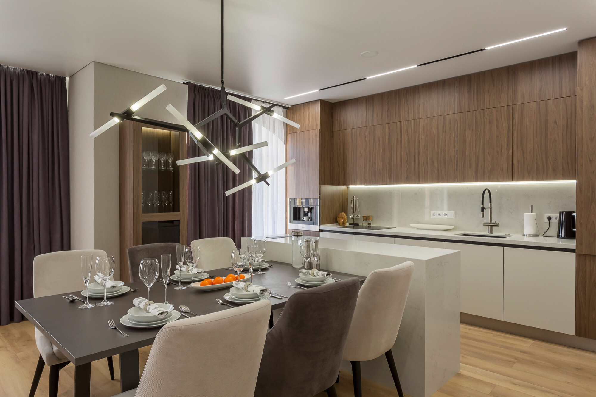 Интерьер кухни с рейками с подсветкой, светильниками над столом и подсветкой светодиодной