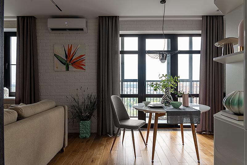 Интерьер кухни с окном, зонированием, балконом и вертикальными жалюзи в стиле лофт