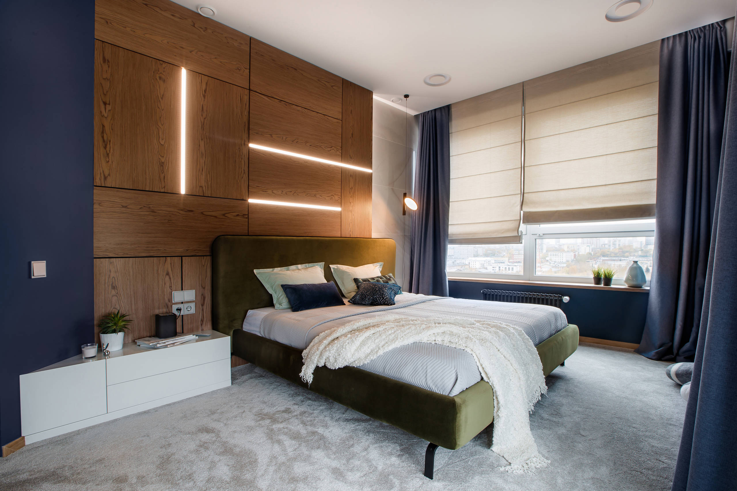 Интерьер спальни с жалюзи, рейками с подсветкой, подсветкой настенной, подсветкой светодиодной и светильниками над кроватью в современном стиле