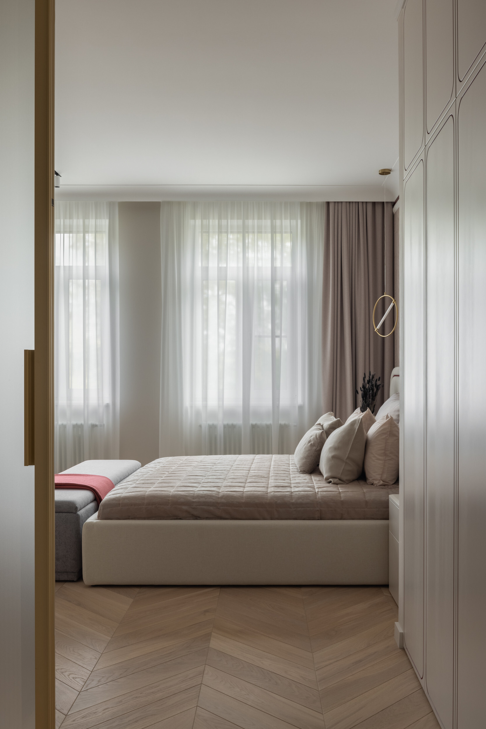 Интерьер спальни с проходной, без окна, проемом, кроватью у двери и светильниками над кроватью в современном стиле
