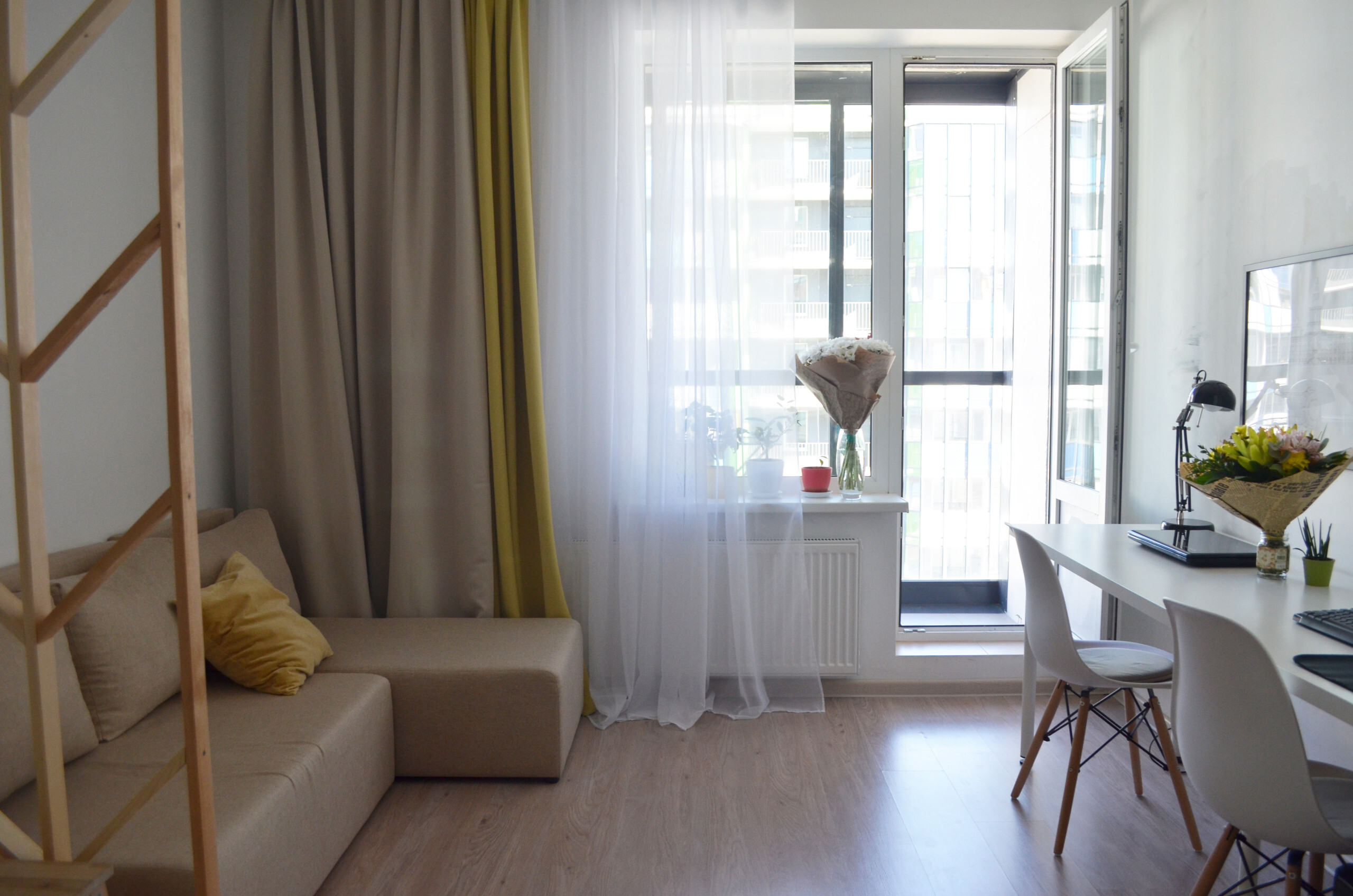 Интерьер гостиной с зонированием шторами, балконом и вертикальными жалюзи в современном стиле